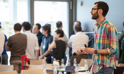 Jake Knapp in piedi e alcune persone sullo sfondo