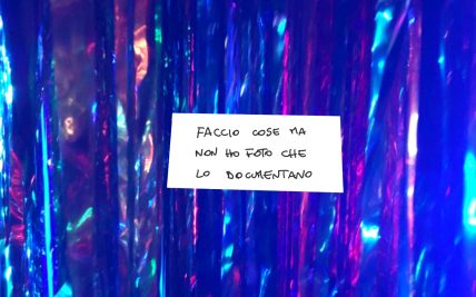 Foto con sfondo blu con un biglietto con su scritto: faccio cose ma non ho foto che lo documentano