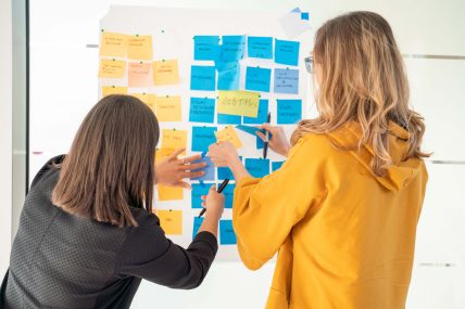 Giulia e Ilenia mentre spostano post it sul muro