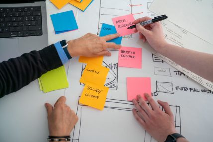 foto di mani di due persone che scrivono post-it