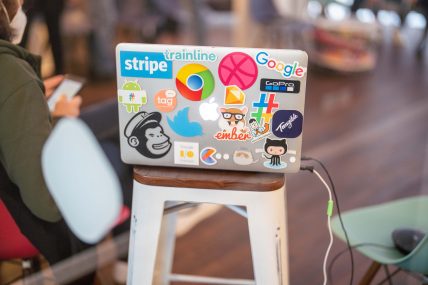 Foto del retro di un mac pieno di adesivi colorati