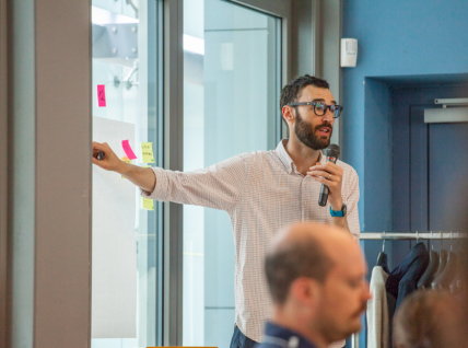 Josh, parla alla classe, con un microfono in mano