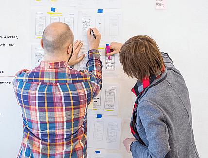 Manuele e Ilaria disegnano schermate su un muro