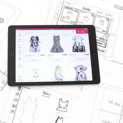 Tablet on sketches and a list of clothes on the screen