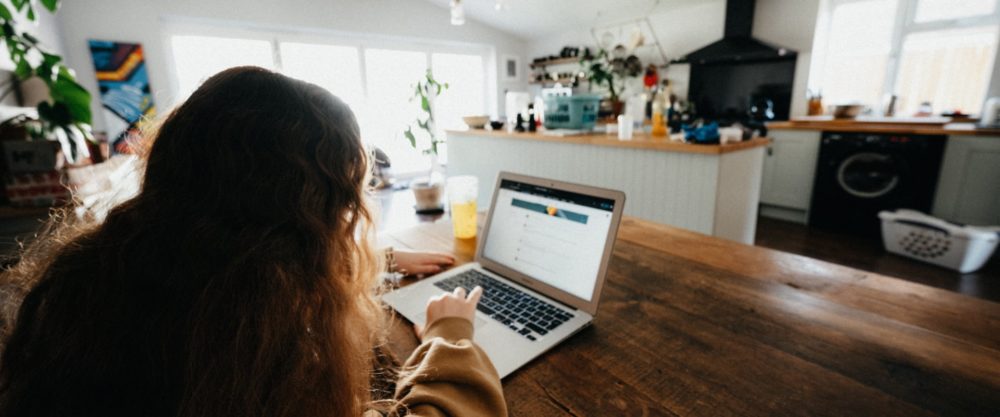 una ragazza di spalle lavora al computer