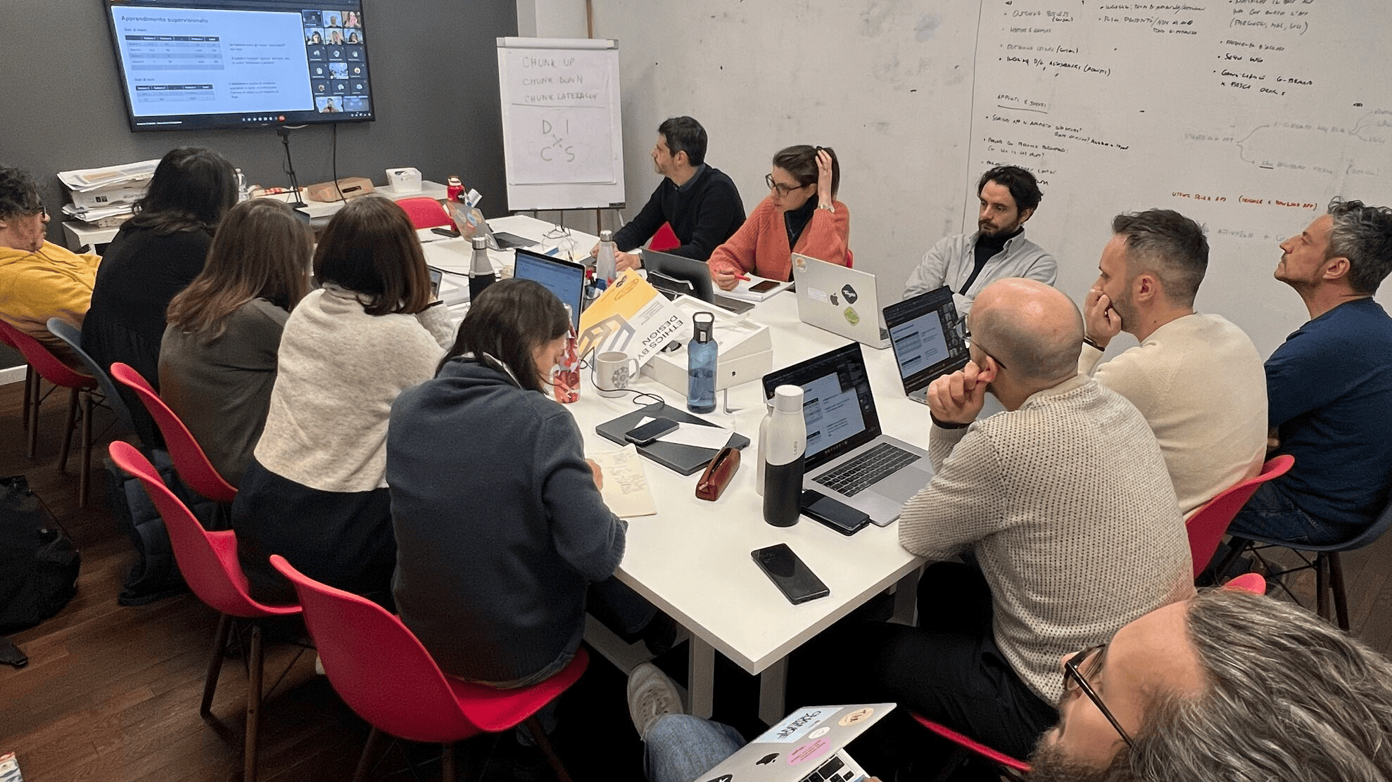 Il team Tangible seduto intorno ad una grande scrivania durante un momento di formazione da remoto.