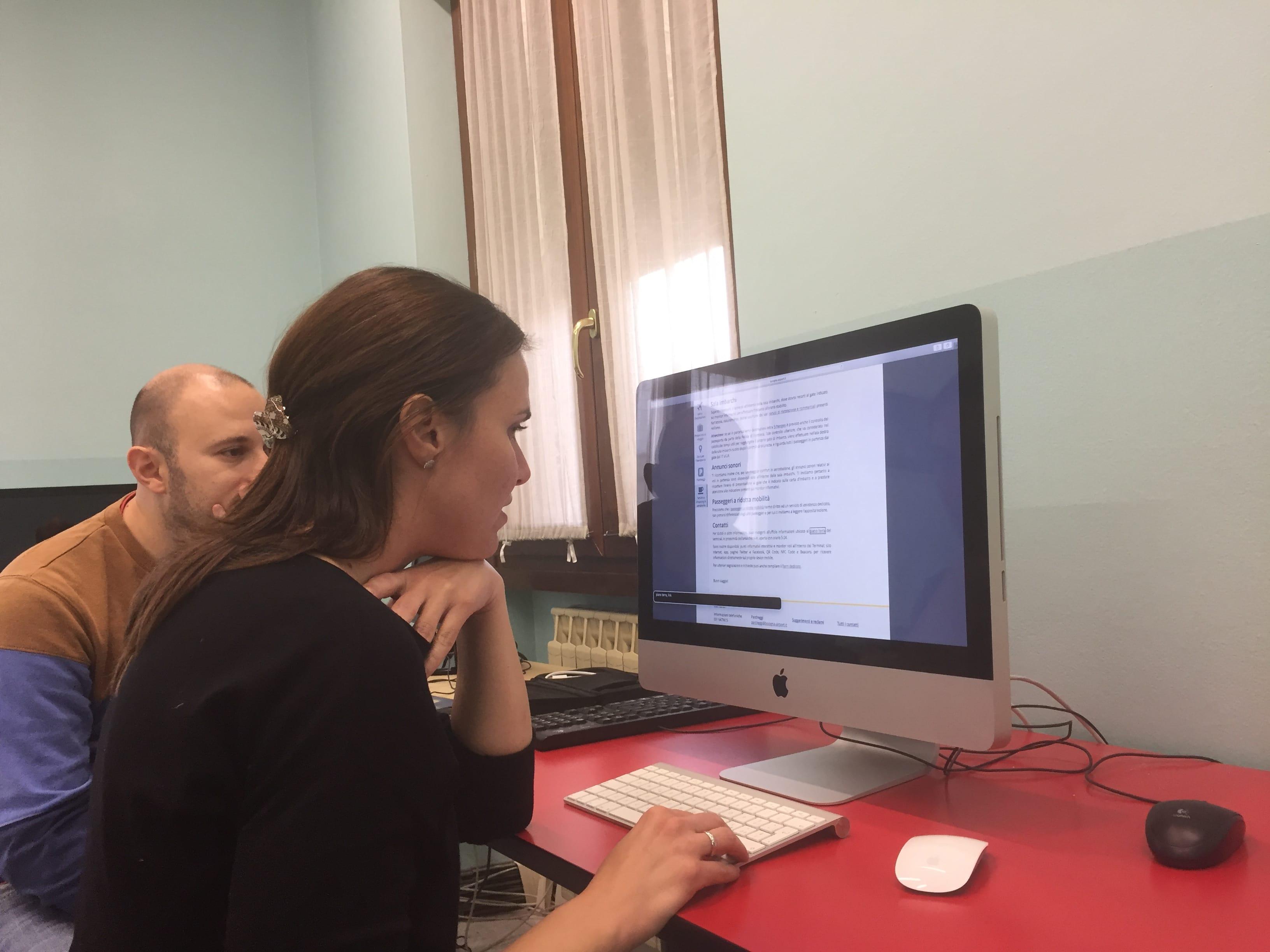 Un uomo e una donna seduti a una scrivania con un computer durante un test di accessibilità.
