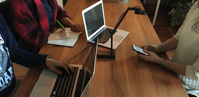 Tre persone sedute a un tavolo con laptop durante un test di accessibilità.